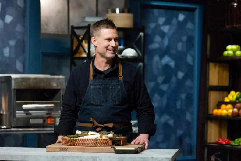 Chef Bryan Voltaggio reveals his final round ingredients, Blue Crab and Paw Paw Vinegar to Host Bobby Flay and Titan Michael Voltaggio, as seen on Bobby’s Triple Threat, Season 4.