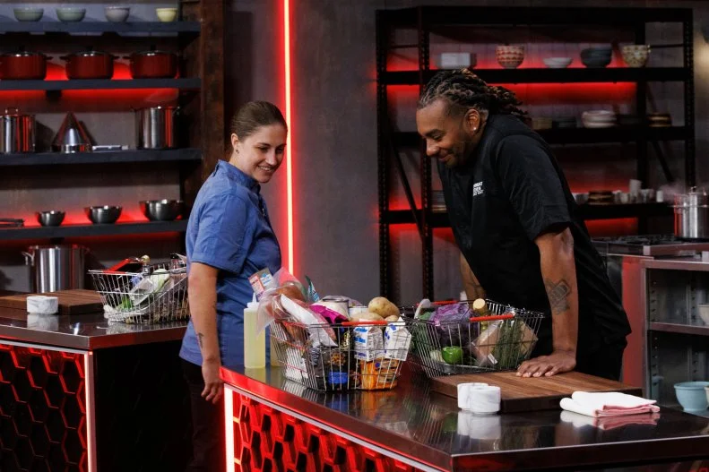 Chef Shibumi Jones sabotages Chris Dobson after winning an auction item before round two, as seen on Cutthroat Kitchen: Knives Out, Season 1.