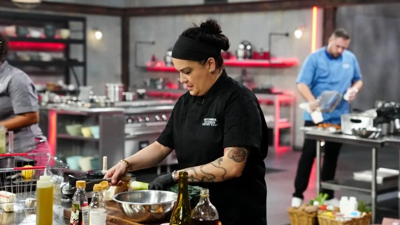 Chef Maria Mazon adjusting mixing bowl at her station, as seen on Cutthroat Kitchen: Knives Out, Season 1.