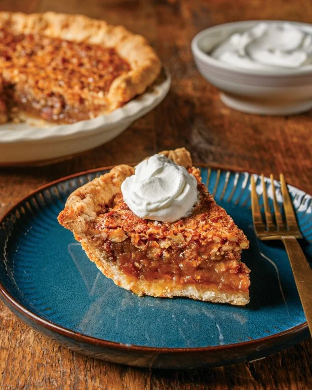 A slice of Ree Drummond's pecan pie on a plate with a fork