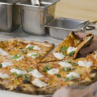 Hand grabbing a slice of the Burrata Pie.  L'Industrie, Brooklyn NY.
