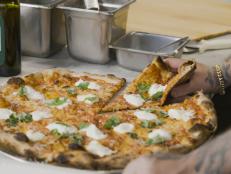 Hand grabbing a slice of the Burrata Pie.  L'Industrie, Brooklyn NY.