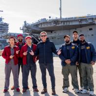 Tyler, Nishaan & Good Fortune Co. in front of the USS George H.W. Bush
