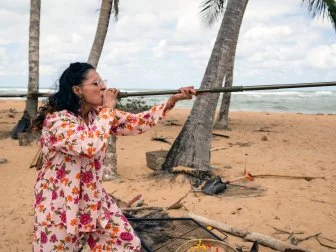 Judge Maneet Chauhan blows into a blowdart, as seen on Chopped Castaways: Season 1