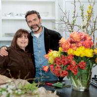 Though Ina is the undeniable mistress of delicious, seemingly effortless cooking, and has planned a delicious menu of a berry studded ricotta cake for breakfast followed by a decadent lunch of smash burgers and champagne, Daniel has some skill sharing of his own to do. He arrives at Ina's East Hampton home with a sumptuous bouquet of flowers for his hostess. Gathering up his bundle of brown paper wrapped flowers, Daniel uses a pair of garden shears and begins to show Ina some of the tips and tricks of flower arranging. First, he separates each type of flower into its own pile before filling a large glass vase with individual bundles of richly colored coral, yellow and pink flowers, to give the feeling of a flower garden with layers of color. “I really try to avoid anything that feels like filler,” says Daniel. As a final touch in the back of the glorious explosion of color, Daniel adds quince branches with tiny white flowers and the vibrant yellow of forsythia branches. “I’m just gobsmacked! I can’t believe how gorgeous this is,” beams Ina.
