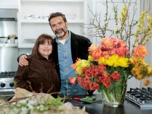 Though Ina is the undeniable mistress of delicious, seemingly effortless cooking, and has planned a delicious menu of a berry studded ricotta cake for breakfast followed by a decadent lunch of smash burgers and champagne, Daniel has some skill sharing of his own to do. He arrives at Ina's East Hampton home with a sumptuous bouquet of flowers for his hostess. Gathering up his bundle of brown paper wrapped flowers, Daniel uses a pair of garden shears and begins to show Ina some of the tips and tricks of flower arranging. First, he separates each type of flower into its own pile before filling a large glass vase with individual bundles of richly colored coral, yellow and pink flowers, to give the feeling of a flower garden with layers of color. “I really try to avoid anything that feels like filler,” says Daniel. As a final touch in the back of the glorious explosion of color, Daniel adds quince branches with tiny white flowers and the vibrant yellow of forsythia branches. “I’m just gobsmacked! I can’t believe how gorgeous this is,” beams Ina.
