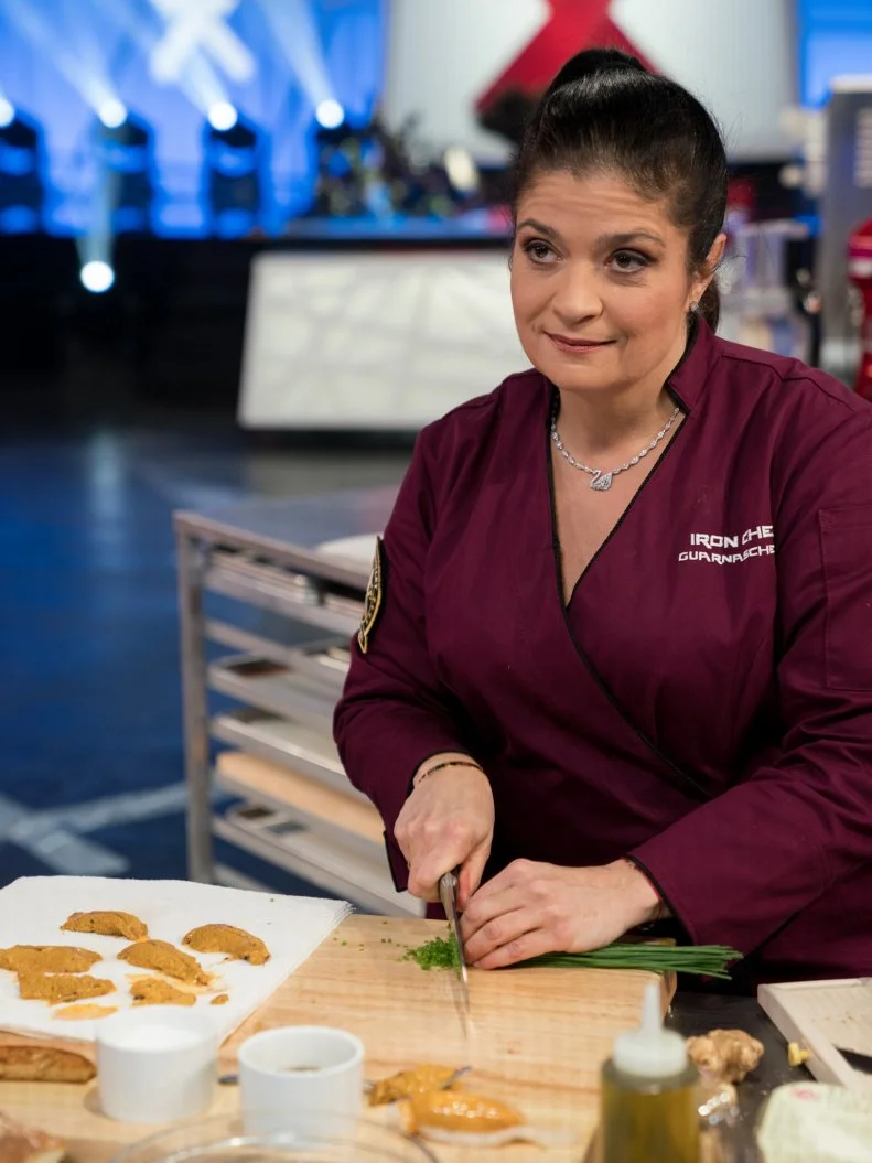 Iron Chef Alex Guarnaschelli cooking with the secret ingredient, sea urchin, in the Iron Chef Gauntlet kitchen, as seen on Iron Chef Gauntlet, Season 2.