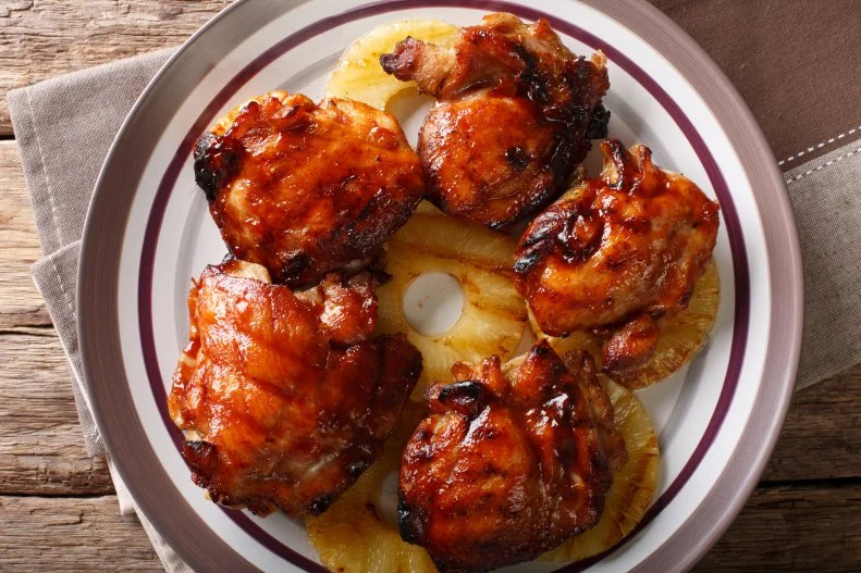 Hawaiian chicken huli huli with pineapple close-up on a plate. horizontal top view from above