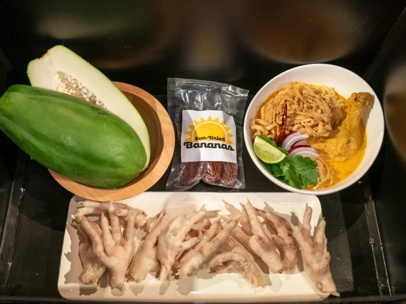 Round 1 ingredients basket with green papaya, sound dried bananas, Khao soi and chicken feet as seen on Chopped: Thai Takedown, Season 61.
