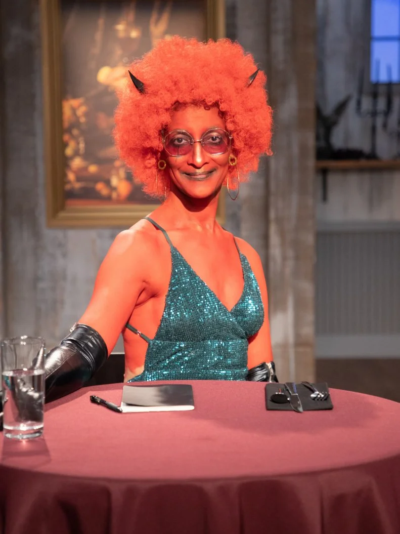 Carla in costume at judges table looking to camera, as seen on Halloween Baking Championship, Season 6.