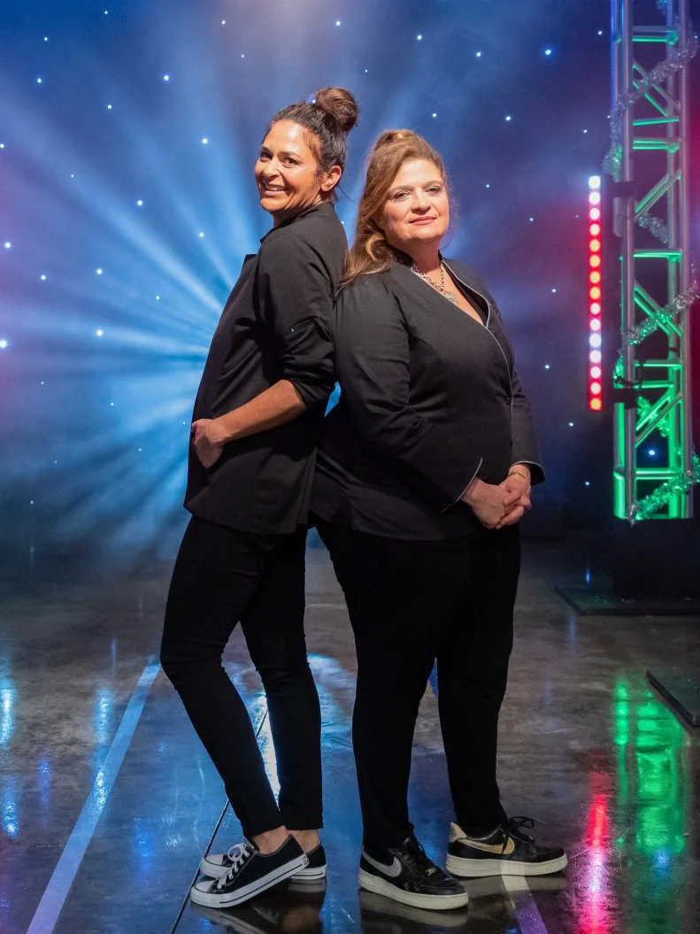 Contestants Antonia Lofaso and Alex Guarnaschelli pose on set, as seen on Tournament of Champions Holiday, Season 1.