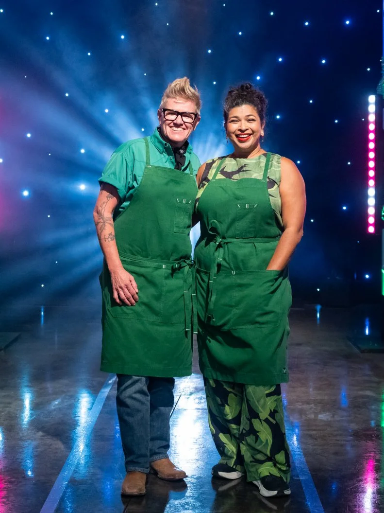 Contestants Crista Luedtke and Aarti Sequeira pose on set, as seen on Tournament of Champions Holiday, Season 1.
