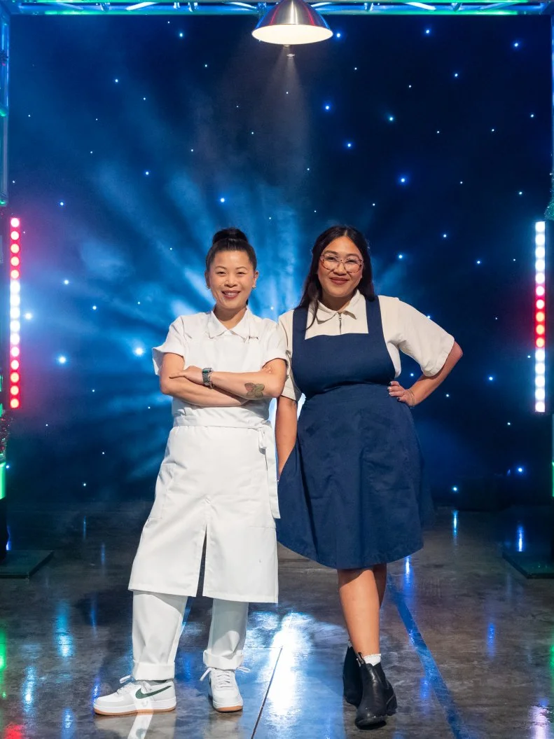 Contestants Mei Lin and Nini Nguyen pose on set, as seen on Tournament of Champions Holiday, Season 1.