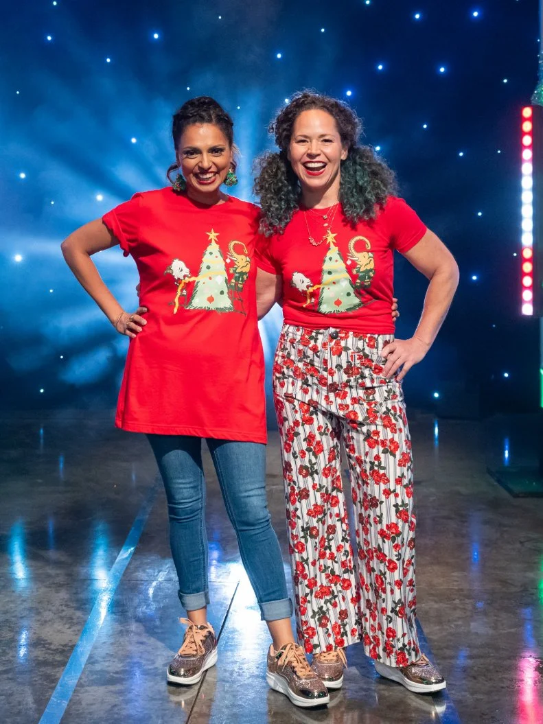 Contestants Maneet Chauhan and Stephanie Izard pose on set, as seen on Tournament of Champions Holiday, Season 1.