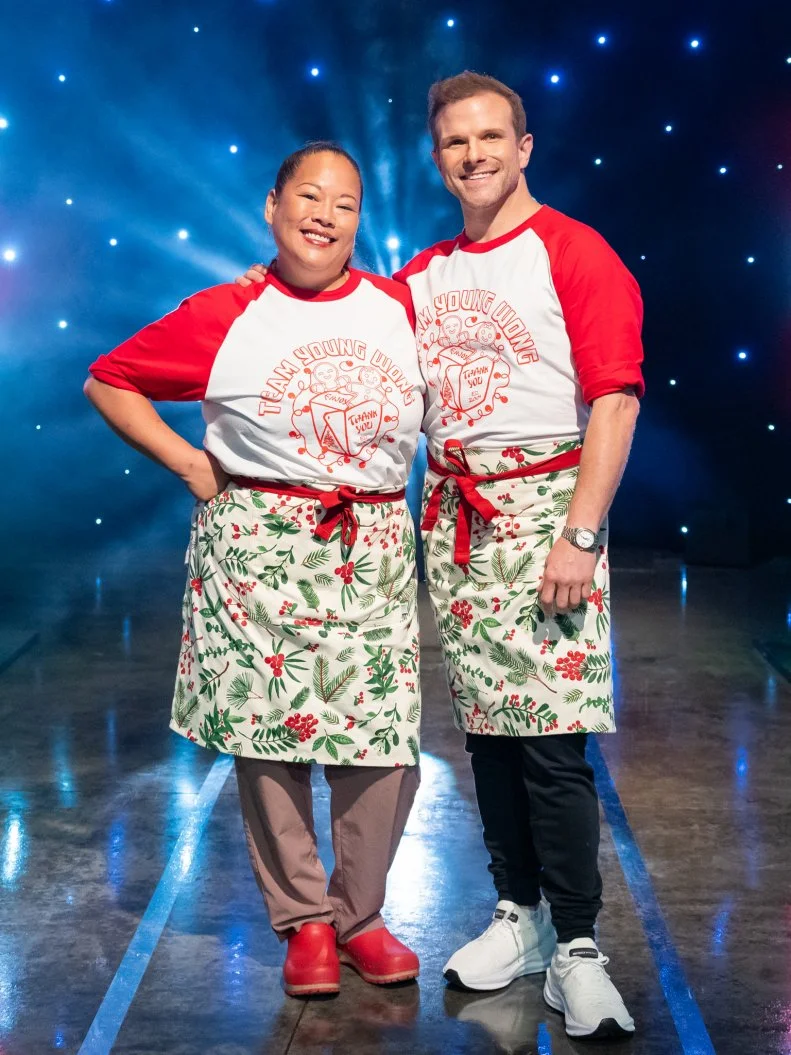 Contestants Lee Anne Wong and Zac Young pose on set, as seen on Tournament of Champions Holiday, Season 1.