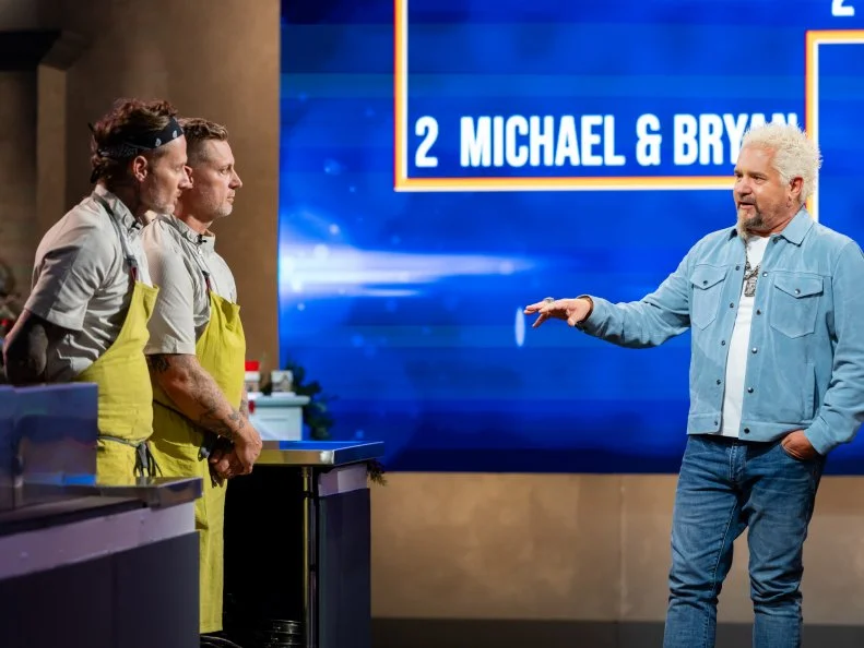 Host Guy Fieri with contestants Michael Voltaggio and Bryan Voltaggio, as seen on Tournament of Champions Holiday, Season 1.