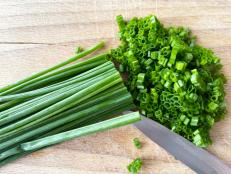 close-up of chopped chives on wooden cutting board