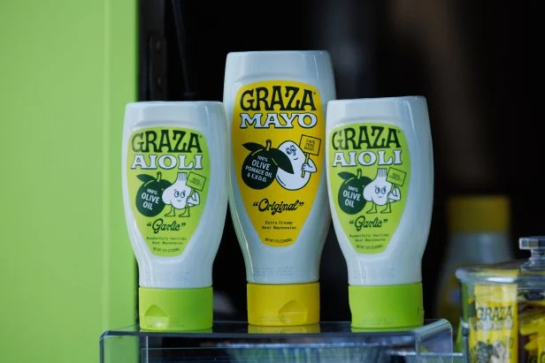 Park goers experience the Food Network x Graza Great Food Truck, as seen in Domino Park, Brooklyn on June 23, 2026. Attendees were served the Calabrian Fried Chicken Sandwich featuring Graza "Garlic" Aioli with a Creamy Cucumber Salad featuring Graza "Original" Olive Oil Mayo.
