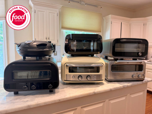 Six indoor pizza ovens in various sizes arranged on a quartz countertop island