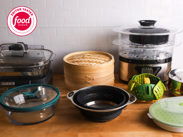 Eight food steamers arranged together on a bamboo countertop and white tile background
