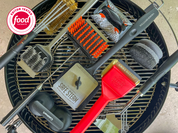 Nine grill brushes, including wire, sponge and steam grill brushes, arranged on a charcoal grill