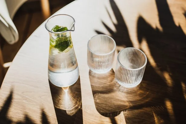 Drink serving in cafe or restaurant. Healthy lifestyle, drinking water during the day. Well body hydration. Table in sunshine, beautiful morning light. Water for breakfast.