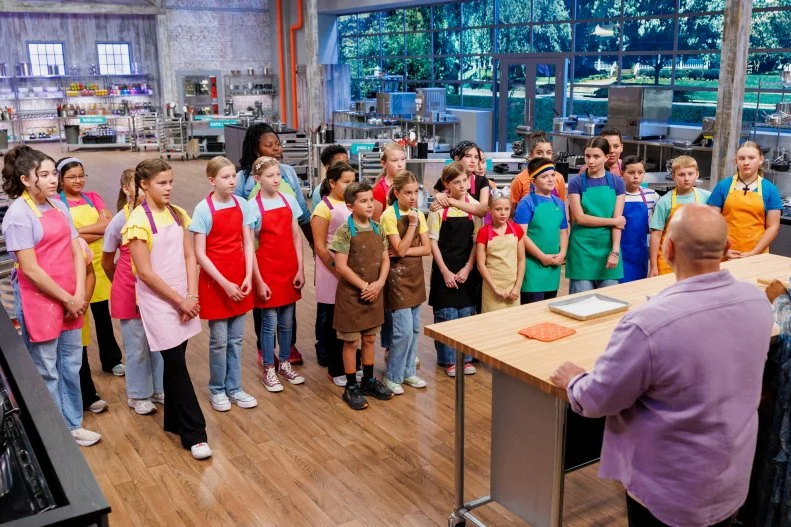 Hosts Duff Goldman and Kardea Brown do a demo bake for Contestants Taanvi and Kavya Bhenderu, Harper and Holland Carroll, Cameron and Abby Bellezza, Genesis and Akbar Brooks, Abigail and Kenneth Wolf, Leia and Kiera Sievert, Amelia and Clara Friesenhahn, Emmett and Maci Sheets, Jovie and Lenore Byler, Michael and Liam Nelson, Norah and Olivia Tatum, and Melody and Leila Nouri, as seen on Baking Championship: Next Gen, Season 1.