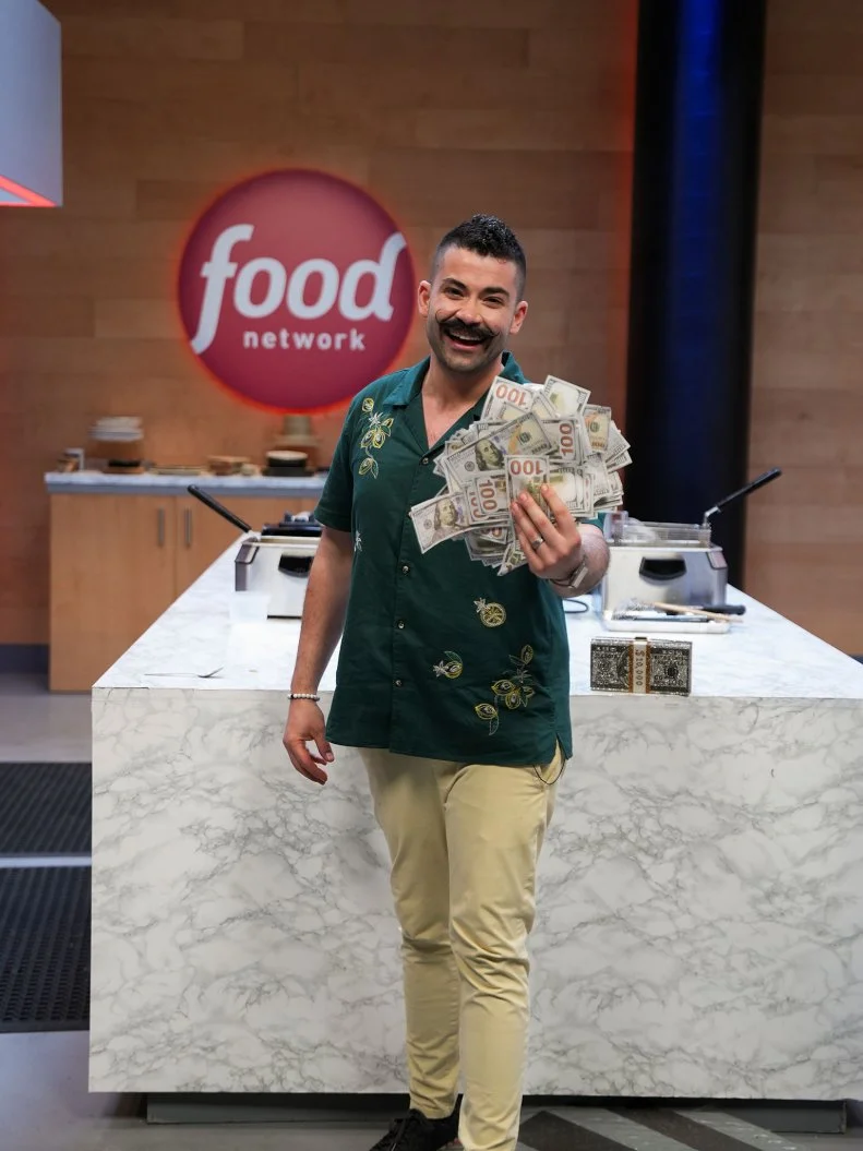 Chef Joe Sasto showing off his winnings , as seen on the Food Network's Guy's Grocery Games.