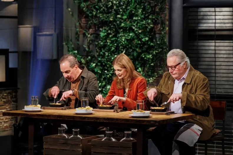 Judges Michael Lomonaco, Melissa Clark, and Jonathan Waxman taste the Round 2 dishes, as seen on Beat Bobby Flay, Season 41.