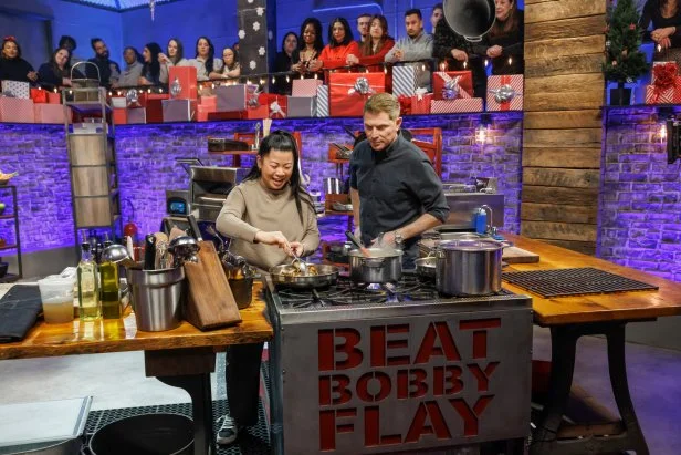 Chef Bobby Flay checks in with contender Mei Lin during Round 2, as seen on Beat Bobby Flay: Holiday Throwdown, Season 4.