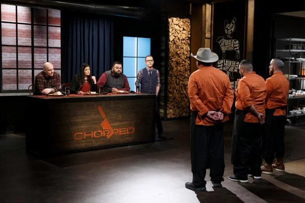 Judges Chris Santos, Alex Guarnaschelli and Ernest Servantes and host Ted Allen face chefs Leonard Botello IV, Esaul Ramos and Carlo Casanova during the entree round tasting, as seen on Chopped, Grill Masters Special.