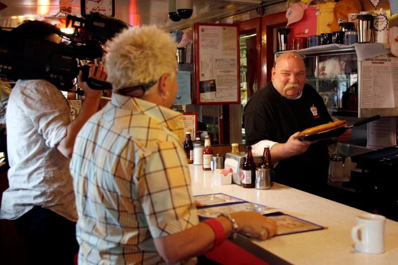 Guy Fieri, Red Arrow Diner, Restaurant, Counter, Man, Cameraman, Menu, Blue And Yellow Shirt, Sunglasses, Behind The Scenes, Diners, Drive-Ins, And Dives