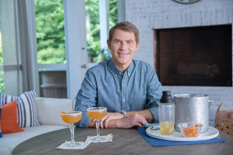 Bobby Flay sits in the sun room at his Hamptons NY home, as seen on The Bobby and Damaris Show, Season 1.