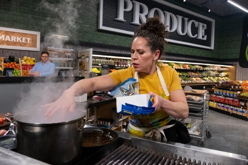 Contestant Stephanie Izard tests the saltiness of the water before adding pasta, as seen on Guy's Grocery Games, Season 33.