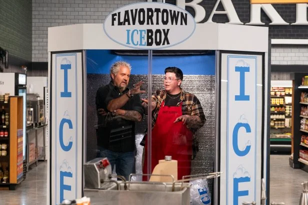 Host Guy Fieri talks with contestant Britt Rescigno in the Icebox, as seen on Guy's Grocery Games, Season 37.