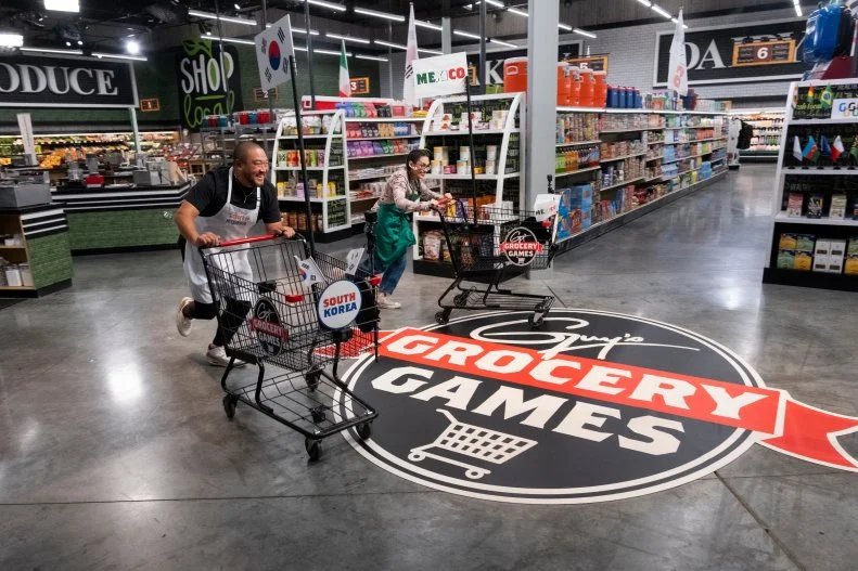 Contestants Kevin Lee and Claudette Zepeda race to shop for ingredients, as seen on Guy's Grocery Games, Season 41.