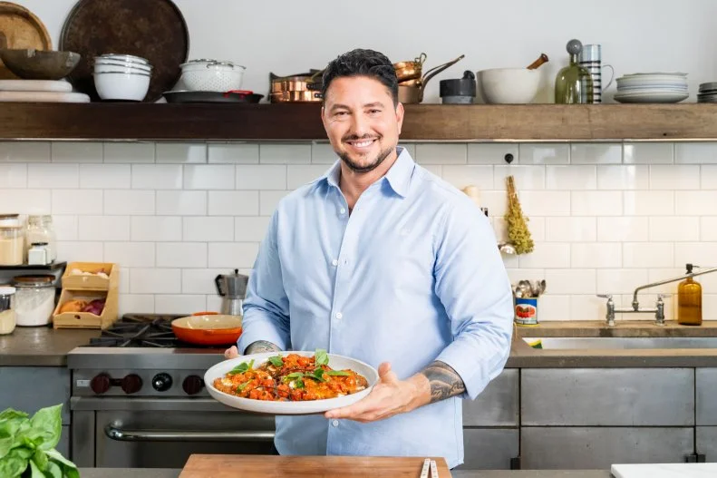 Host Gabe Bertaccini posed with Chicken Parmesan, as seen on Cook Like an Italian with Gabe Bertaccini, Season 1.