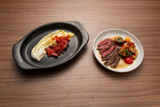 Chef Ashleigh Shanti's Round 2 dishes, grilled skirt steak with salmon roe hot sauce, and charred cabbage, with piquillo marinated heirloom tomatoes and charred eggplant, with piquillo marinated seared skirt steak, as seen on Bobby's Triple Threat, Season 3.