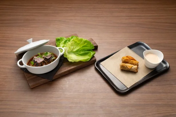 Titan Tiffany Derry's Round 2 dishes, charred beef patties with shallot chili sauce wrapped in lettuce, with cheeseburger spring roll: ground beef and caramelized shallots, white cheddar and gruyere, with sweet shallot thousand island sauce titan, as seen on Bobby's Triple Threat, Season 3.