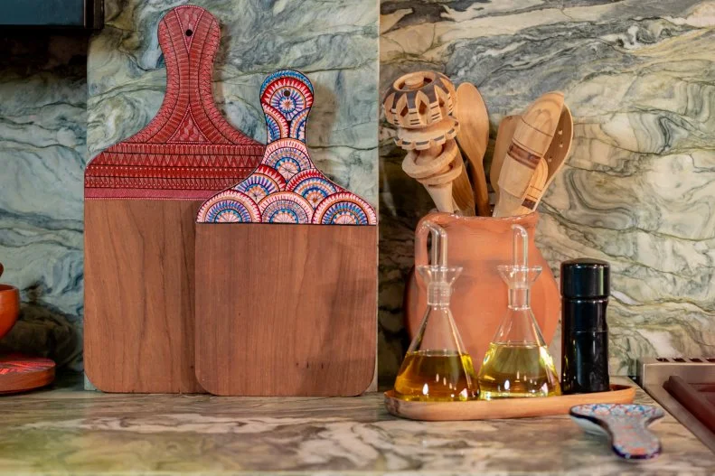 The cuisine but also the handicrafts of Mexico are on full display in Rick's kitchen where beautifully ornamented cutting boards and a grouping of handmade spoons and utensils are set against the green-tinged stone that Rick chose to echo the colors of the foliage right outside the kitchen door.