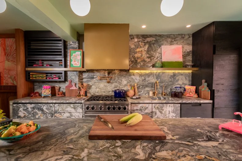 There's no better stage for a chef than a grand kitchen island like this one in stone handpicked by Rick to draw out the shades of green in the plants right outside the kitchen door.