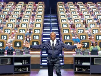 Host Terry Crews posed in front of contestants, as seen on 100 Cooks, Season 1.