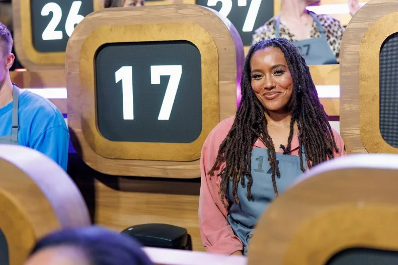 100 Cooks contestant Maya Christian sits among the competition