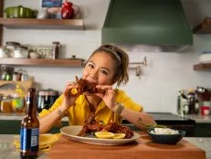 Host Esther Choi tastes her Korean Fried Chicken with Pickled Yuja Daikon.