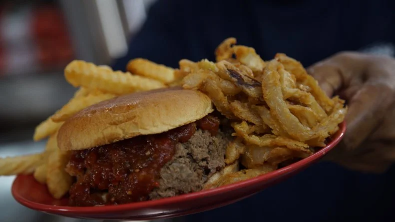 Chef with featured burger from The Beacon Drive In.
