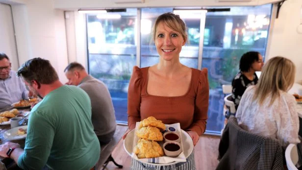 Suzanne Vizeethann holding a plate of biscuits and jam at her Buttermilk Kitchen restaurant.