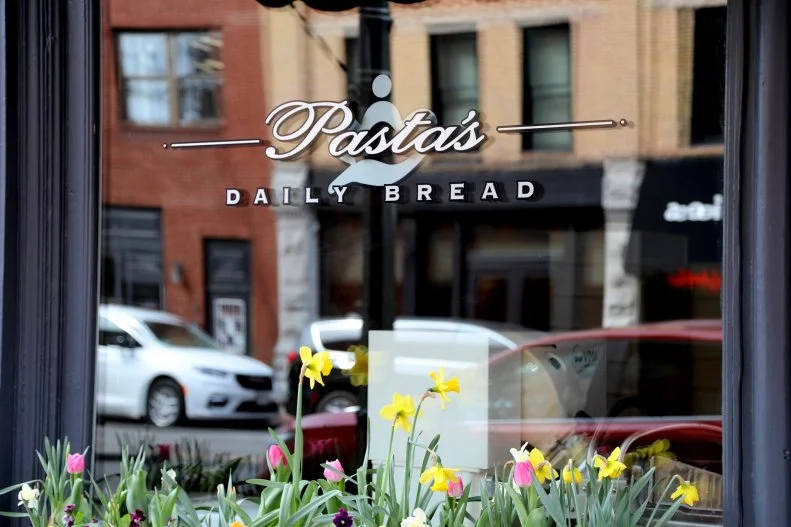 Painted window sign showing the business name, Pasta's Daily Bread.