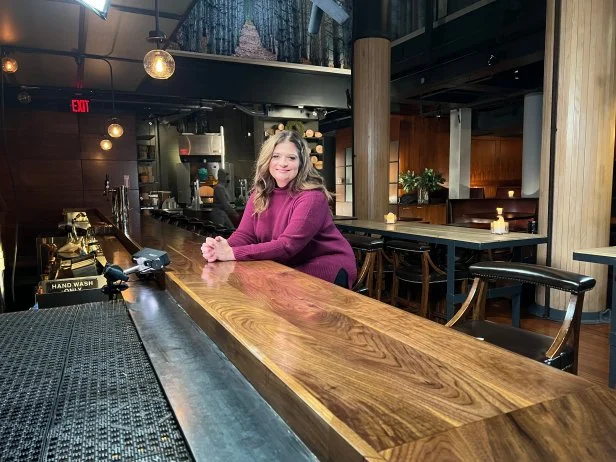 Alex Guarnashelli sitting at the bar in the restaurant, Butter