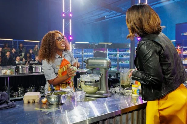 Host Laila Ali talks to contestant Tia Raiford during competition, as seen on Chef Grudge Match, Season 1.