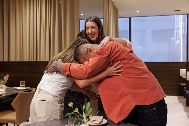 Jen Agg and Aaron Sanchez in a group hug with Joanna L and Jeanette L in the newly designed resturant